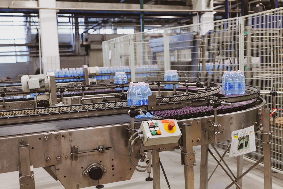 Transportbånd og emballeringslinje i industrielt anlæg, illustrationsfoto